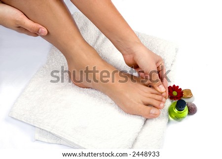 Hand massaging toes, as part of self reflexology treatment. Suitable for spa and healthcare setting, isolated with copyspace