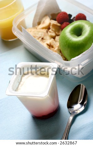 Quick and convenient snack or light lunch pack made up of an apple, raspberries, orange juice and fruit yogurt. Concept of healthy eating.