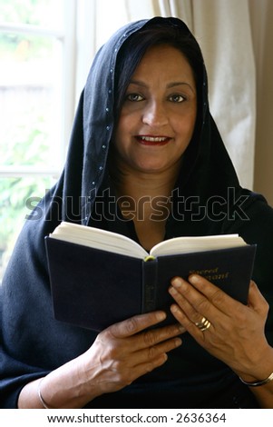 Beautiful Asian woman reading her religious book.Concept of faith and belief.