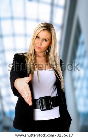 Attractive caucasian businesswoman stretching out her right hand as a gesture for a handshake, smartly attired, against white background with copyspace.