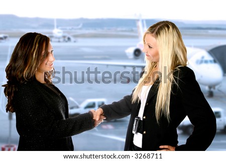 Two businesswoman giving each other a handshake at the airport departure hall.