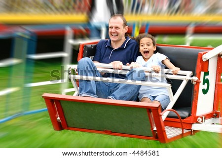 Faces of excitement from a father and daughter as they enjoy the fast octopus ride in the park