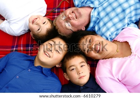 Beautiful family of intermarriage couple from Thailand and caucasian with their three boys in the park