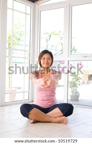 Young Asian female doing her arm stretch to elongates the muscle on underneath of arm after her exercise.
