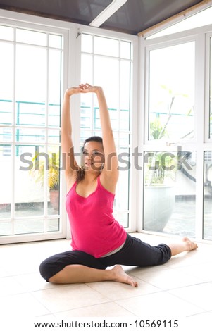 Young Asian female doing stretching exercise in a calm home environment