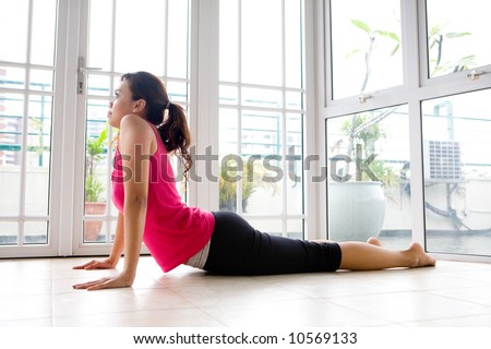 Young Asian female stretching her back to strengthen, in a calm home environment