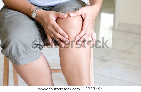 Woman tenderly massaging her painful knee