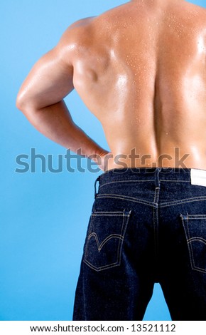 The back of a very muscular man in denim trousers.