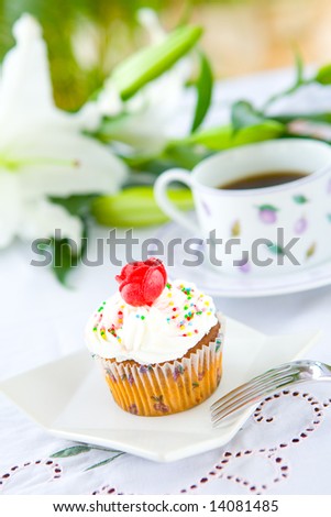 stock photo Single pretty cupcake with butter icing and red rose biscuit 