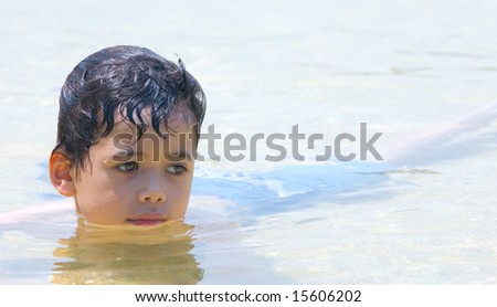 Young boy submerged in a wading pool at water park