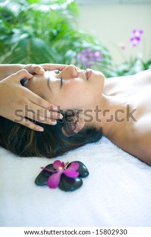 Young woman restful while being in head massage therapy in spa