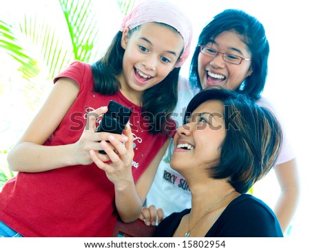 Young girls happy and laughing while sharing an information on a cellphone