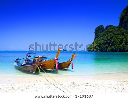 stock photo : Long tailboats by the shore at Hong Island, Krabi Thailand against beautiful clear blue sky