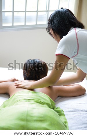 Woman having back massage therapy as part of health and wellbeing