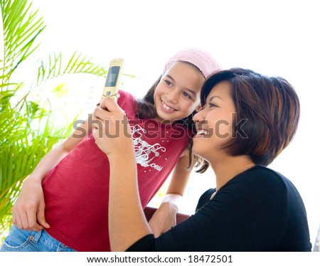 Woman sharing information on her cell phone with a younger child.