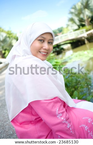 Beautiful Muslim Malay woman smiling in an outdoor park