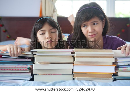 Two unhappy sisters not enjoying the books they have to read