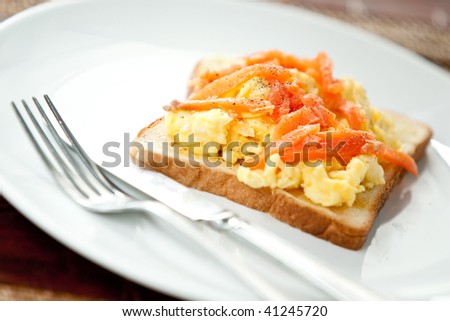 Delicious scrambled eggs on toast with smoke salmon