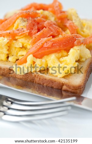 Closeup of smoke salmon and scrambled egg on toast.