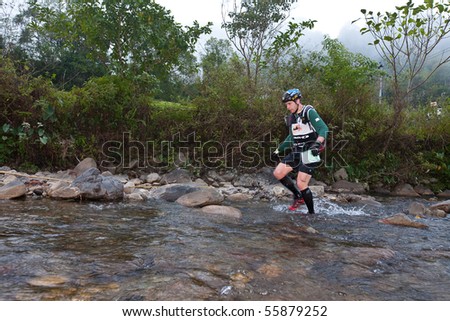 SABAH, MALAYSIA - APRIL 2: Participant wading through the river to get to destination within the race in the Sabah Adventure Challenge, April 2, 2010 in Sabah, Malaysia.