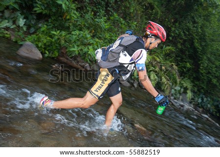SABAH, MALAYSIA - APRIL 2ND.  A racer from a participating team makes his way across a river in the morning hours at the Sabah Adventure Challenge, April 2nd, 2010, Sabah, Malaysia.