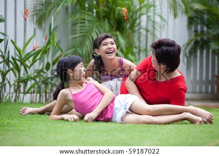 Chinese mom having fun with her daughters in the garden