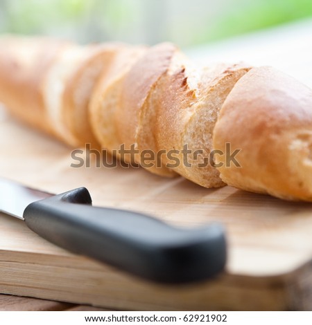 Freshly baked baguette sliced on wooden board