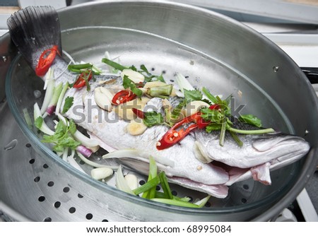 Fresh sea bass fish with oriental ingredients ready for steaming.