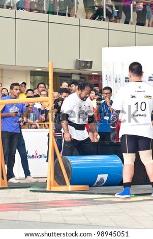 TOA PAYOH, SINGAPORE - MARCH 24 : Contender for Strongman  Yusri Bin Ali attempts the 300kg Yoke walk in the Strongman Challenge 2012 on March 24, in Toa Payoh Hub, Singapore.