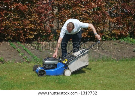 Handsome Middle aged man working in the garden with lawnmower,