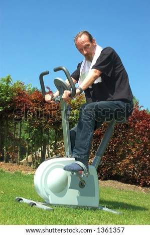 Fitness bicycle for home use. Middle aged man working out, bicycling.