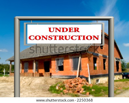 Under construction sign in front of house in progress,   Real estate concept. Clipping path on sign.