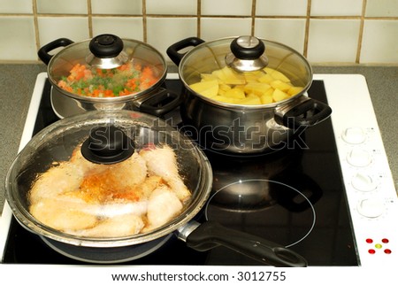 Dinner time, cooking  potatoes, peas and carrots stewed with onions and sugar, fried chicken legs. Food nutrition concept.