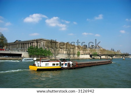 Spring in Paris, the seine river with cargo boats, vibrant blue spring sky.  Tourism, transportation, industry concept