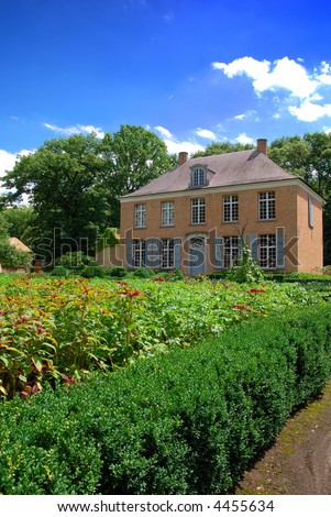 Residential house, villa in the suburbs with formal garden, bright sunny day, blue sky.  Real estate, luxury concept.