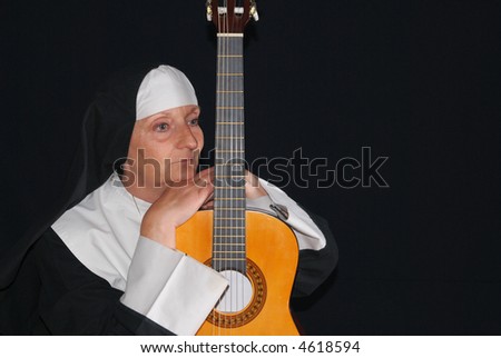 Middle aged nun playing the guitar.  Religion, christianity, lifestyle, entertainment, music, concept