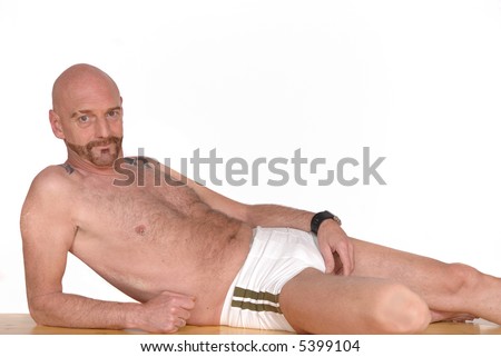 Attractive bearded middle aged man in swimming suit, alternative lifestyle, tattoo and piercing