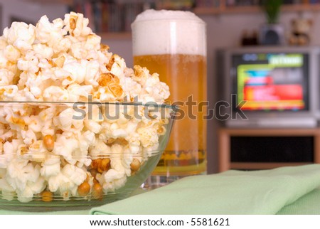 Having a snack on a television evening.  Popcorn and beer. Food, nutrition,  relaxation, media concept.