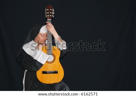 Middle aged nun playing the guitar, head resting a against instrument, pensive look on face, eyes closed