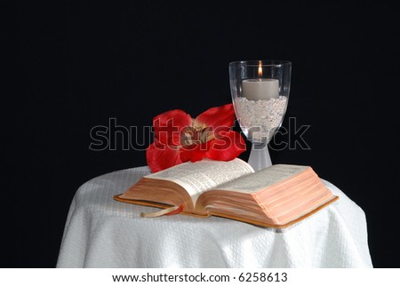 bible with candle and flower, hibiscus on cloth