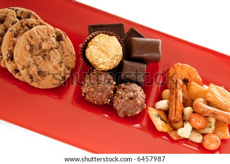 Belgium chocolates truffles, brownies and mix of cookies and nuts on a decorative red glass  plate.
