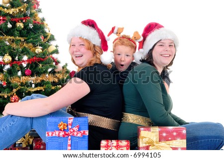 happy youngsters, teenage girls and one boy around Xmas, Christmas three with presents, gifts.  White background.