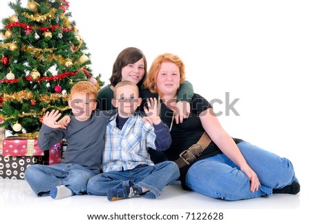 Two happy youngster, teenage girls and one boy around Xmas, Christmas three with presents, gifts.  White background.