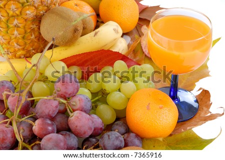 Fresh seasonal fruit, pineapple, apples, bananas, kiwi, grapes, mandarin, orange and glass fruit juice on reflective underground