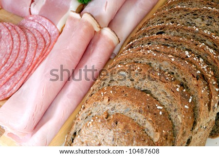 Breakfast, variety of bread meat on cutting board, white background, studio shot