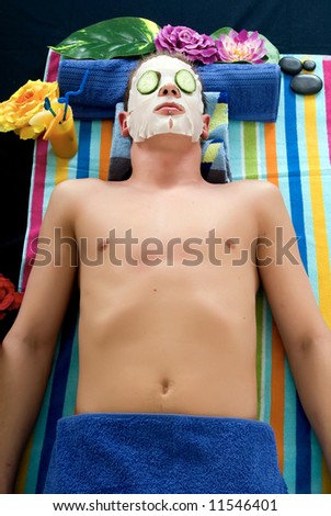 Attractive handsome young man with face mask in spa center. White background,