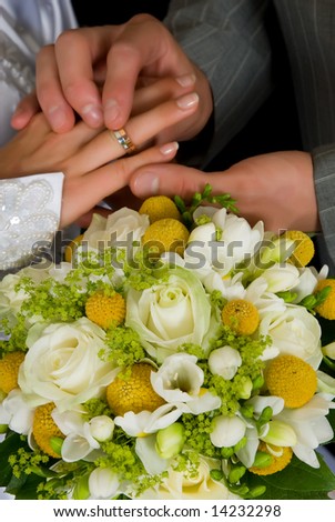 stock photo Young couple putting on wedding ring bouquet flowers in front 