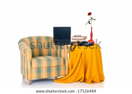 Sofa next to table with books, phone, rose flower and glass of cognac,  white background,  studio shot, reflective surface.