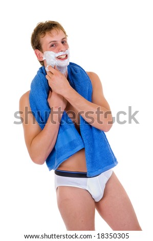 Young handsome man in briefs towel around neck, shaving,  Studio shot, white background