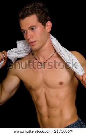 Young attractive male body builder, demonstrating artistic pose. Studio shot, black background.